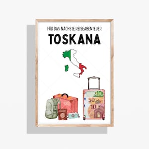 Könnte beinhalten: Ein gerahmter Druck mit dem Text "FÜR DAS NÄCHSTE REISEABENTEUER TOSKANA" über einer Karte Italiens in den Farben der italienischen Flagge. Das Bild zeigt einen grünen Rucksack, einen roten Koffer, einen Reisepass, eine Kamera und einen Rollkoffer mit Euro-Scheinen.