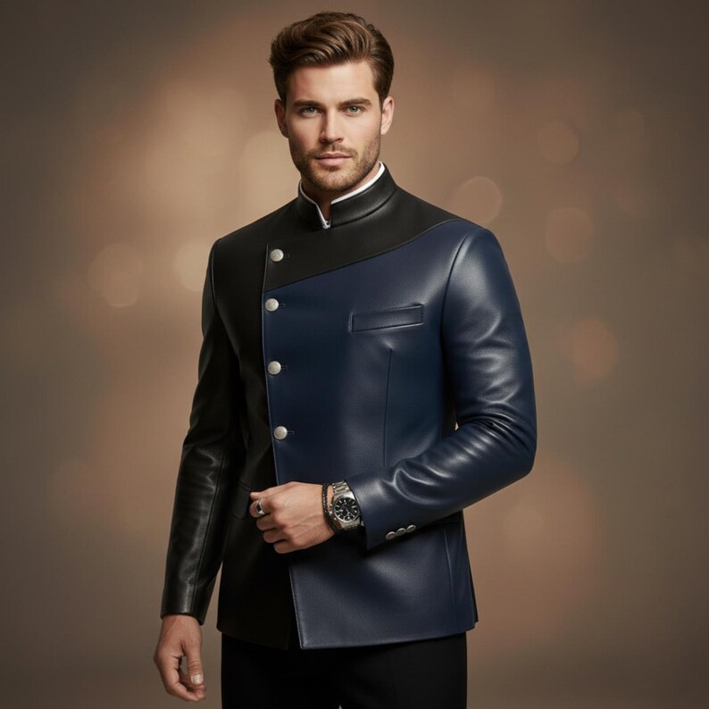 May include: A two-tone leather jacket in black and navy blue. The jacket features a mandarin collar, silver buttons, and a tailored fit. The model is wearing a white shirt underneath.