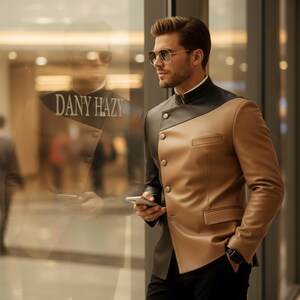 May include: A two-tone leather jacket in black and tan with a mandarin collar and button closure. The jacket has a diagonal color block design and a small pocket. The text "DANY HAZY" is visible in the reflection.