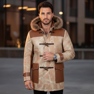 May include: A tan and brown leather coat with a fur-lined hood. The coat features toggle closures, brown leather accents on the shoulders, pockets, and cuffs. The coat is worn over a black shirt.