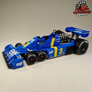 Puede incluir: Modelo de coche de carreras azul y amarillo con el número 3. El coche tiene los logotipos de Goodyear y Elf. El modelo es una réplica detallada de un coche de Fórmula 1 clásico.