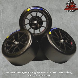 May include: Three black racing tires with black rims are stacked together. Each tire has a blue and yellow Michelin logo. The text "Porsche 911 GT3 R REXY AO Racing (Lego 42224)" is at the bottom of the image.