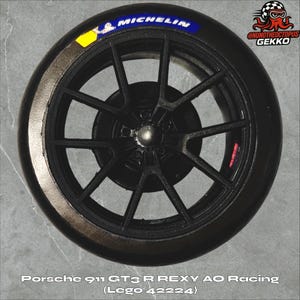 May include: Black racing wheel with a Michelin tire. The wheel has a dark gray spoke design and a silver center cap. The tire has the text "MICHELIN" in blue and white. The text "Porsche 911 GT3 R REXY AO Racing (Lego 42224)" is at the bottom.