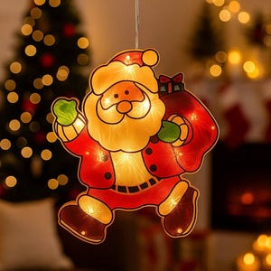 Puede incluir: Decoración luminosa de Papá Noel. La figura es roja, con barba y gorro amarillos, y un guante verde. Papá Noel lleva un saco rojo y está iluminado con luces blancas cálidas, ideal para Navidad.