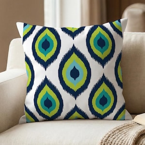 May include: A square throw pillow featuring a repeating pattern of stylized, teardrop-shaped motifs in shades of navy blue, lime green, and bright turquoise against a crisp white background, creating a bold and symmetrical graphic design.