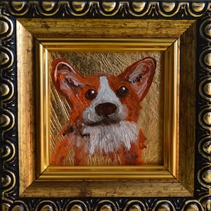 May include: An oil painting of a Corgi dog with orange and white fur, set against a metallic gold background. The artwork is enclosed in a square, ornate frame featuring a black and gold decorative pattern with a scalloped edge design.