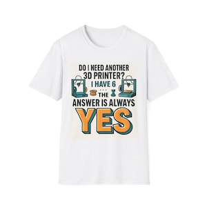 Op de afbeelding: Wit t-shirt met een kleurrijke afbeelding. De afbeelding luidt "DO I NEED ANOTHER 3D PRINTER? I HAVE 6 THE ANSWER IS ALWAYS YES" in een speels lettertype. Het ontwerp bevat illustraties van 3D-printers.