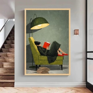 May include: A framed art print depicts a person reclining in a green armchair, reading a red book under a green lamp. The person wears a dark dress and red shoes. A stack of books sits on the floor. The background is a muted green.