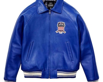 May include: A vibrant blue leather jacket with a classic collar and a zip-up front. The jacket features a patch with an American flag design and the brand name. The cuffs and hem have white and blue striped detailing.