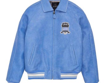 May include: A light blue bomber jacket with a zip-up front, collar, and ribbed cuffs and hem. The jacket features a patch on the chest with the brand name and logo. The jacket has two front pockets and a soft interior lining.