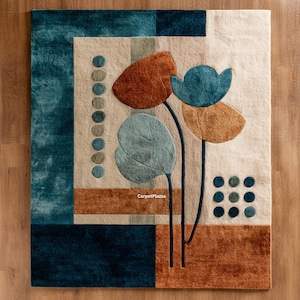 May include: A rectangular rug with a floral design. The rug features a cream-colored background with teal, brown, and orange accents. The design includes stylized flowers and geometric shapes. The text "CarpetPlazza" is visible.