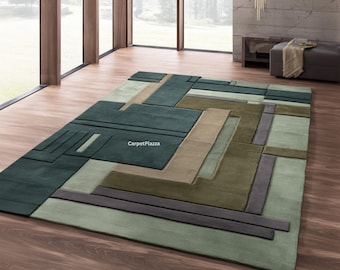 May include: Geometric patterned area rug in shades of green, gray, and beige. The rug features a modern design with rectangular and linear shapes. The text "CarpetPlazza" is visible on the rug.