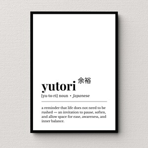 May include: A black framed print with the word "yutori" in a bold, sans-serif font. Below, the definition reads: "a reminder that life does not need to be rushed - an invitation to pause, soften, and allow space for ease, awareness, and inner balance."