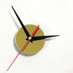 May include: A gold-colored clock face with black hour and minute hands and a red second hand. The hands are positioned to indicate the time. The clock face is round and has a simple, modern design.