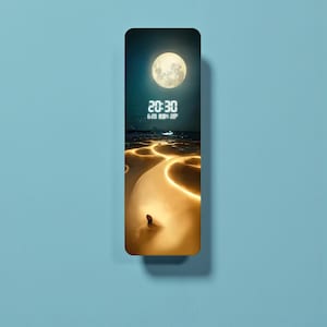 Puede incluir: Un reloj de pared rectangular con un diseño de escena nocturna. La esfera del reloj presenta una luna llena, una pantalla digital que muestra "20:30" y un paisaje con senderos brillantes. El reloj está sobre un fondo azul claro.