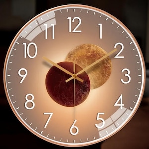 May include: A round wall clock with a bronze-colored frame and a gradient brown face. The clock features white numerals, gold-colored hands, and two abstract circular designs in shades of red and gold. The clock's diameter is approximately 12 inches.