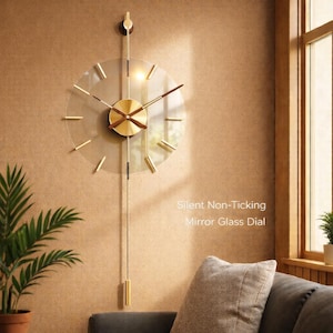Könnte beinhalten: Eine moderne Wanduhr mit einem Zifferblatt aus klarem Glas und goldfarbenen Akzenten. Die Uhr hat ein Pendel und ein rundes Zifferblatt mit goldenen Zeigern und Markierungen. Der Text "Silent Non-Ticking Mirror Glass Dial" ist sichtbar.