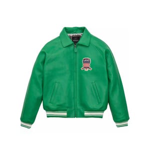 Pu&ograve; includere: Giacca in pelle verde brillante con chiusura a zip e colletto. Presenta una toppa sul petto con un disegno della bandiera americana e la scritta "AVIREX". I polsini e l'orlo sono rifiniti con dettagli a righe bianche e verdi.