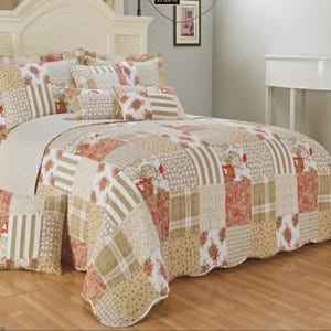 May include: A patchwork quilt set in beige and red tones, with floral and striped designs. The set includes a quilt, pillow shams, and decorative pillows. The bed has a white headboard and a nightstand. The quilt measures approximately 33.12 cm in height and 43.59 cm in width.
