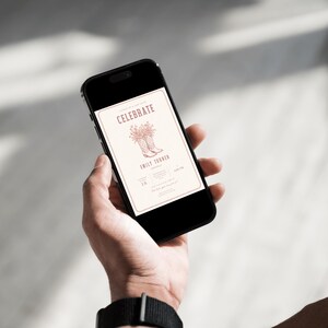 K&ouml;nnte beinhalten: Ein schwarzes Smartphone, das eine digitale Einladung auf seinem Bildschirm anzeigt. Die Einladung zeigt das Wort CELEBRATE in einer Serifenschrift, eine Strichzeichnung von Cowboystiefeln mit Blumen und den Namen EMILY THARIN auf hellem Grund.