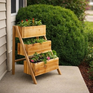 May include: A three-tiered wooden planter stand with a natural light brown finish. The structure features three rectangular boxes arranged in a cascading staircase design, each filled with green foliage and small red and pink flowers.