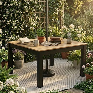 May include: A square outdoor table with a light wood top and black legs. The table is set with books, mugs, and potted plants. The table is surrounded by lush greenery, including flowering plants and ferns. An umbrella is attached to the table.