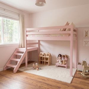 May include: A light pink loft bed with a built-in staircase on the left side. The elevated sleeping area features horizontal safety rails. Beneath the bed, there is an open space containing a wooden dollhouse, three dolls, two plush toys, and blocks.