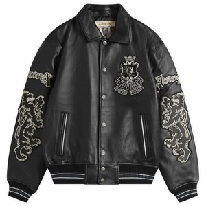 May include: Black leather jacket with a button-up front, embroidered lion and logo patches. The jacket has a classic collar, white stripes on the cuffs and hem, and the brand name "Avirex" is visible.