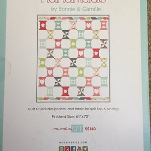 May include: A quilt kit by Bonnie & Camille with a finished size of 155cm x 183cm. The kit includes fabric and pattern for the quilt top and binding. The quilt design features a repeating pattern of spools in red, green, black, and blue.