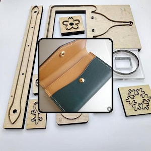 May include: A collection of wooden leathercraft tools and a green and tan leather wallet. The tools include various shapes and sizes for cutting and shaping leather, including a flower, snowflake, and lizard. The wallet is open, revealing the interior.