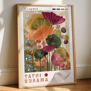 May include: A framed art print with a vibrant floral design. The artwork displays stylized flowers in orange, purple, green, and yellow against a neutral backdrop. The print includes Japanese text and the name "Yayoi Kusama".