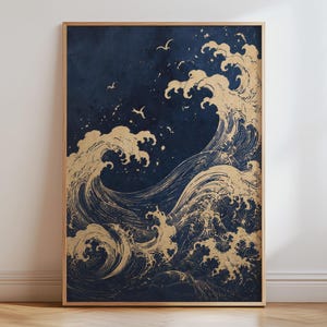 May include: A rectangular wall art print featuring a dark navy blue background with gold-colored illustrations of large, crashing ocean waves and several small birds flying in the upper portion of the composition, all encased in a thin wooden frame.