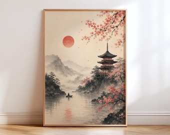 May include: A framed wall art print featuring a landscape with a multi-tiered pagoda on a rocky cliff, a small boat on a calm lake, and a large red sun in a pale sky. Pink cherry blossom branches frame the scene, with misty mountains in the distance.