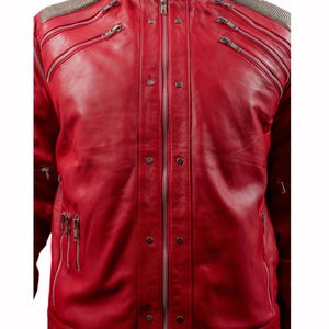 Pode incluir: Jaqueta de couro vermelho vibrante com m&uacute;ltiplos z&iacute;peres prateados e detalhes de ombro com tachas prateadas. A jaqueta tem gola alta e corte sob medida, com v&aacute;rios bolsos com z&iacute;per e costuras decorativas.