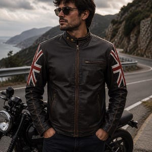 May include: A dark brown leather jacket featuring a mandarin collar with two snap buttons, a full-length front zipper, and a chest pocket. The sleeves are accented with a red, white, and blue Union Jack flag design on the upper arms.