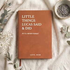 May include: A rectangular, rust-colored notebook with white text that reads: LITTLE THINGS LUCAS SAID & DID, SO I'LL NEVER FORGET, and LOVE, MOM. The notebook features a smooth, solid-colored cover and a thin ribbon bookmark extending from the bottom.