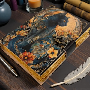 May include: A decorative journal with a black cat illustration on the cover, featuring orange and yellow flowers and a brass clasp. A silver pen and a white feather are placed nearby. The journal's pages have a vintage, aged appearance.