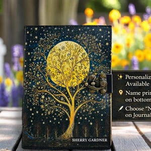 May include: A decorative journal with a tree and moon design. The cover features a large yellow moon and a tree with intricate branches against a dark blue background with stars. The journal has a metal clasp and the name SHERRY GARDNER is printed on the bottom.