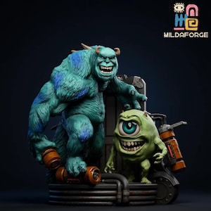 以下が含まれることがあります： 2体の漫画のモンスターを特徴とする詳細な彫刻。大きなモンスターは青緑色で青色のアクセントがあり、小さなモンスターは緑色で片目です。彫刻は暗い背景で、「MILDAFORGE」というテキストがあります。