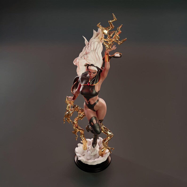 May include: A detailed figurine of Storm, a character from the X-Men. The statue features Storm in a dynamic pose, with flowing white hair and a black and gold costume. Gold lightning bolts emanate from her hands, and she stands on a cloud base.