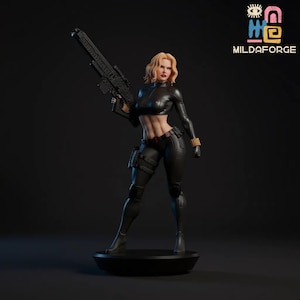 Pode incluir: Figura detalhada de uma personagem feminina em roupa preta, segurando uma arma grande. A figura tem cabelo loiro e está em uma base preta. O texto "MILDAFORGE" está no canto superior direito.