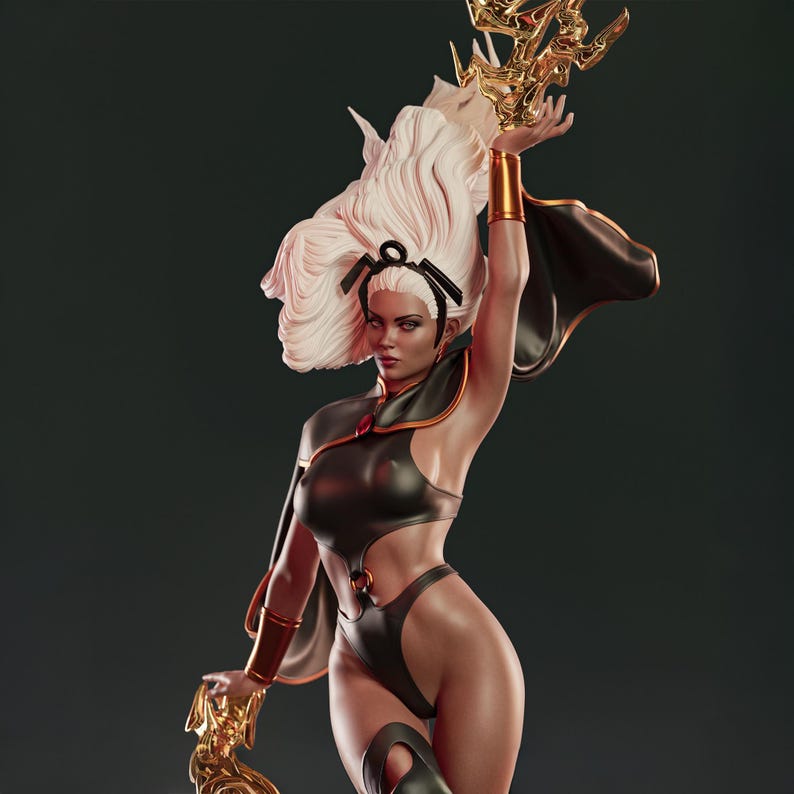 May include: A detailed statue of a character with white hair and a black and gold outfit. The figure is holding a golden object aloft, with a cape flowing behind. The statue has a dynamic pose and is set against a dark background.