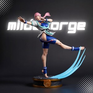 Puede incluir: Una figura coleccionable de un personaje con cabello rosa en una pose dinámica de artes marciales, vistiendo un traje azul y blanco con un cinturón negro. La figura se apoya sobre una base con un efecto de energía azul y el texto "mildforge".