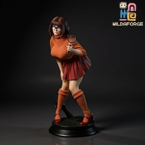 Könnte beinhalten: Figur einer Zeichentrickfigur in einem orangefarbenen Rollkragenpullover, rotem Rock und orangefarbenen kniehohen Socken, die eine Lupe hält. Die Figur trägt eine Brille und rote Schuhe. Die Figur steht auf einem schwarzen Sockel. Das Logo "MILDAFORGE" befindet sich in der oberen rechten Ecke.