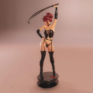 May include: A figurine of a woman in a black corset, garter belt, and thigh-high boots, holding a whip. Her hair is styled in a bun. The figurine stands on a round, black base with a red emblem.