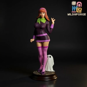May include: A figurine of a woman in a purple dress, pink stockings, and purple shoes, with a green scarf and red hair. A white ghost figure stands next to her. The figurine is on a brown base. The logo "MILDAFORGE" is in the upper right corner.