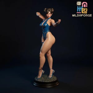 May include: A detailed figurine of a woman in a blue bodysuit, posed in a fighting stance. The figure has dark hair styled in buns and is wearing blue sandals. The base is dark with a textured surface. The logo "MILDAFORGE" is in the upper right corner.