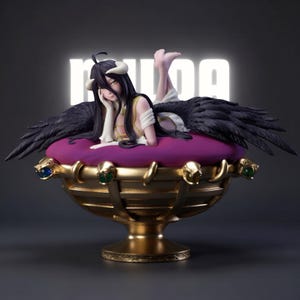 May include: A detailed figurine of a character with black wings, horns, and long black hair, reclining on a purple cushion. The figure is set within a gold-colored decorative bowl with serpent and jewel accents. The background is dark with the word "MUDA" in white.