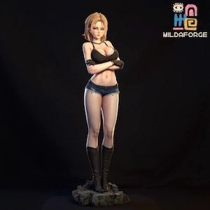 May include: A detailed figurine of a female character with blonde hair, wearing a black top, denim shorts, and knee-high boots. The figure has arms crossed and stands on a rocky base. The background is dark, and a logo is visible.