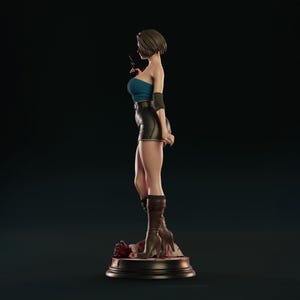 May include: A detailed figurine of a woman in a blue tube top, black shorts, and brown boots, holding a gun. The figure stands on a round base with a dark background. The figurine is approximately 30 cm tall.
